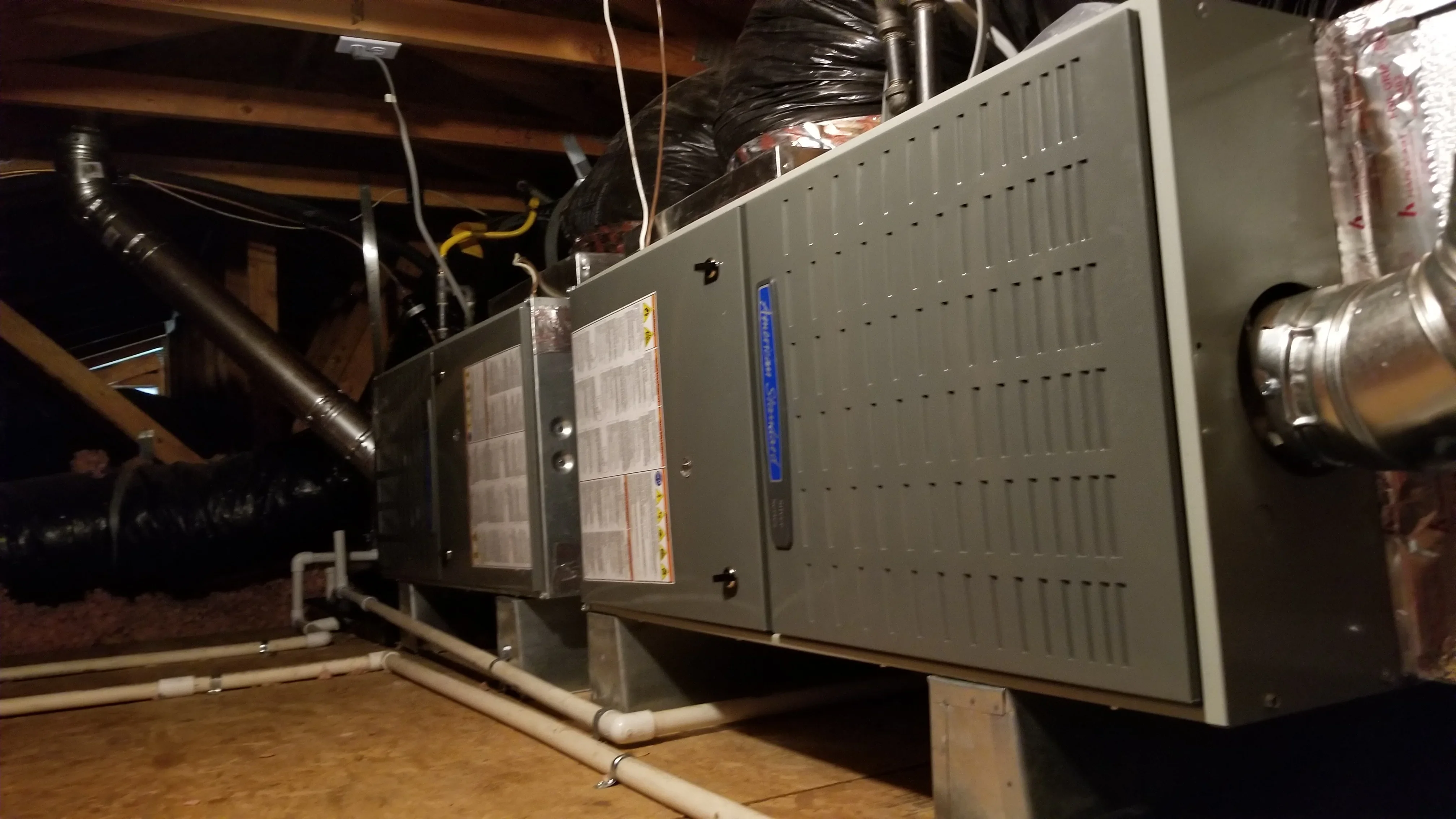 Newly installed high-efficiency furnace with metal ductwork and PVC venting in basement