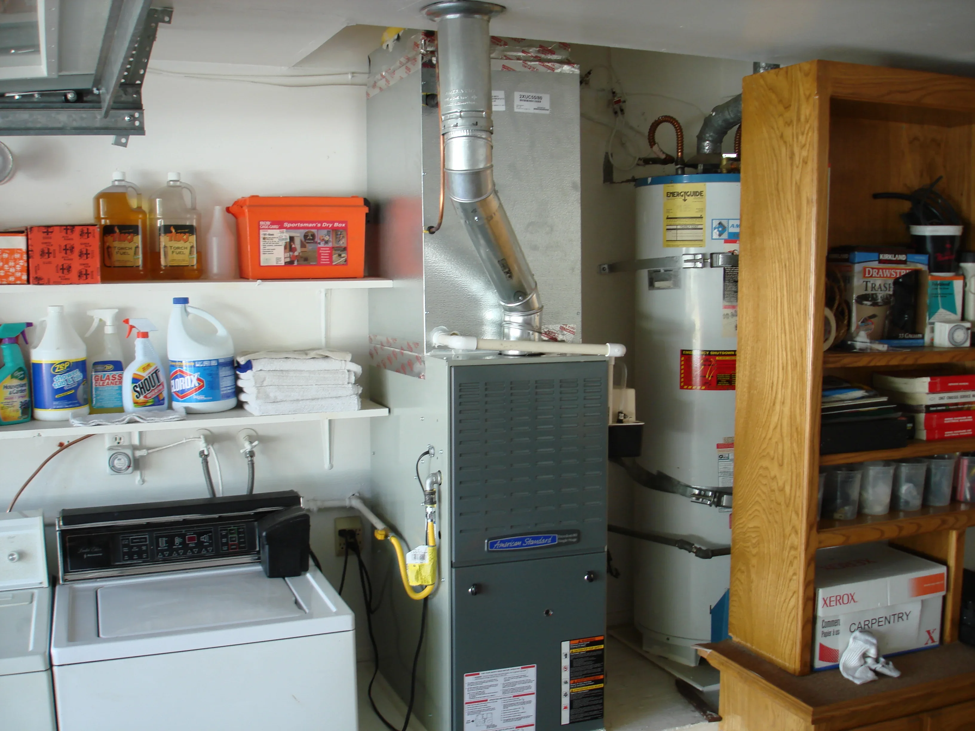 Installed furnace with ductwork, water heater, and organized utility shelves in garage