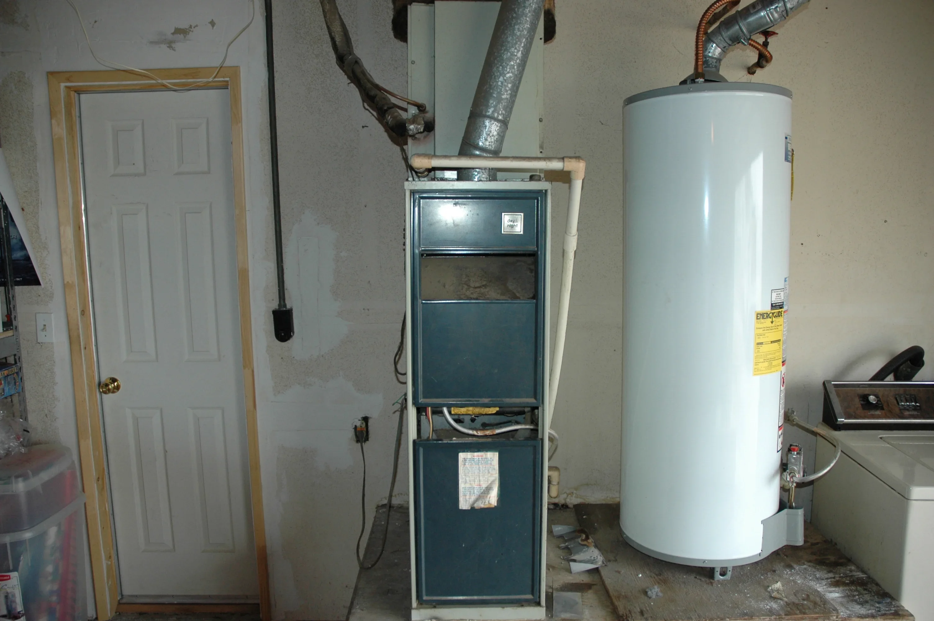 New furnace and water heater installation in utility room with metal ductwork