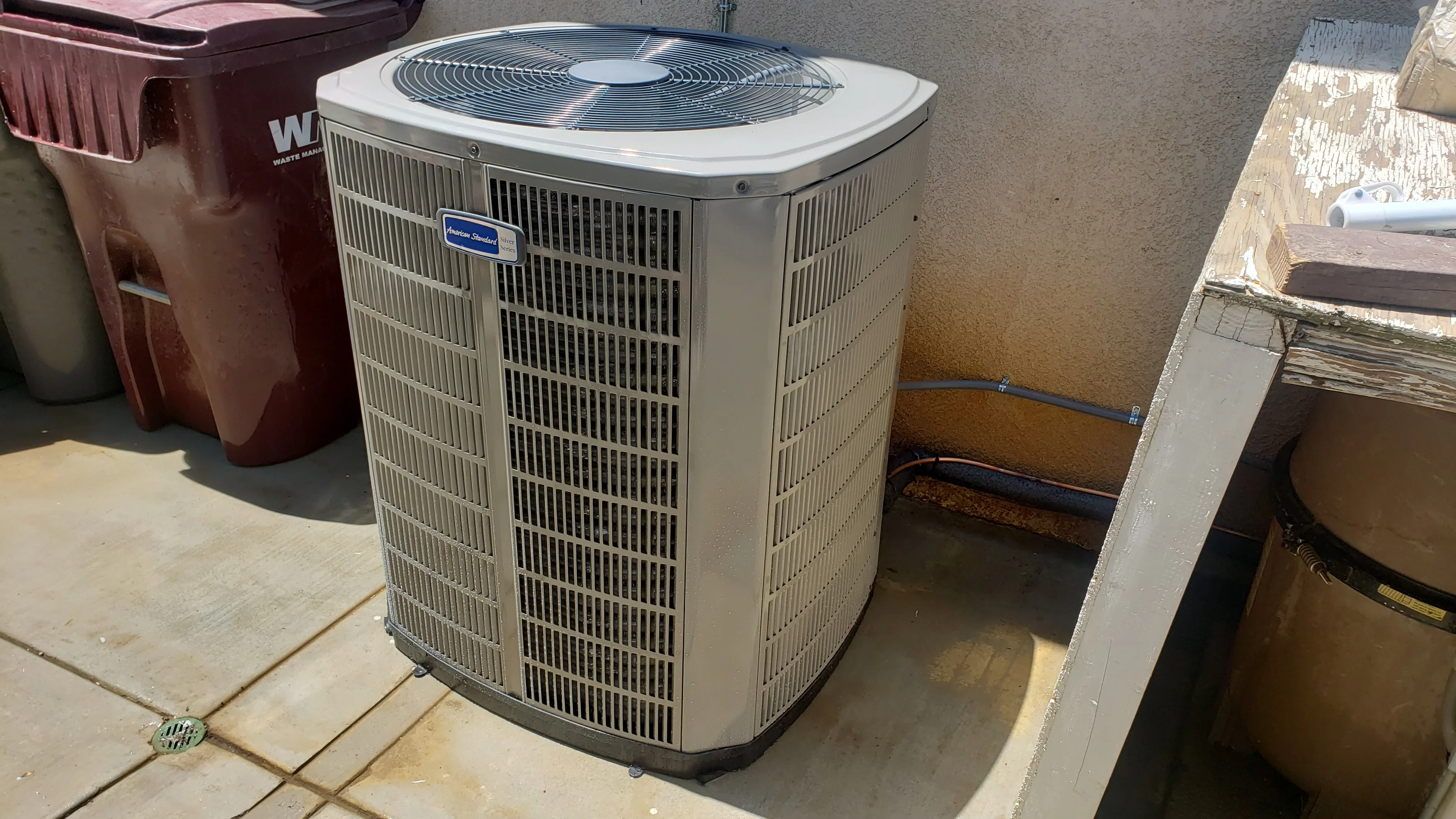 New American Standard AC condenser unit installed on concrete pad with proper clearance