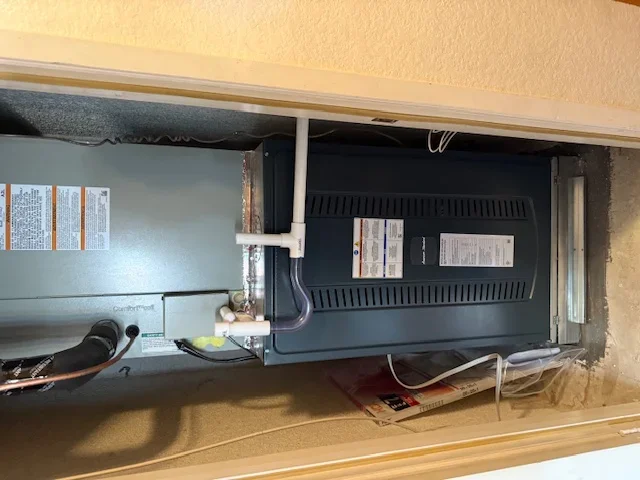 Installed electrical breaker panel and HVAC air handler unit in mechanical closet