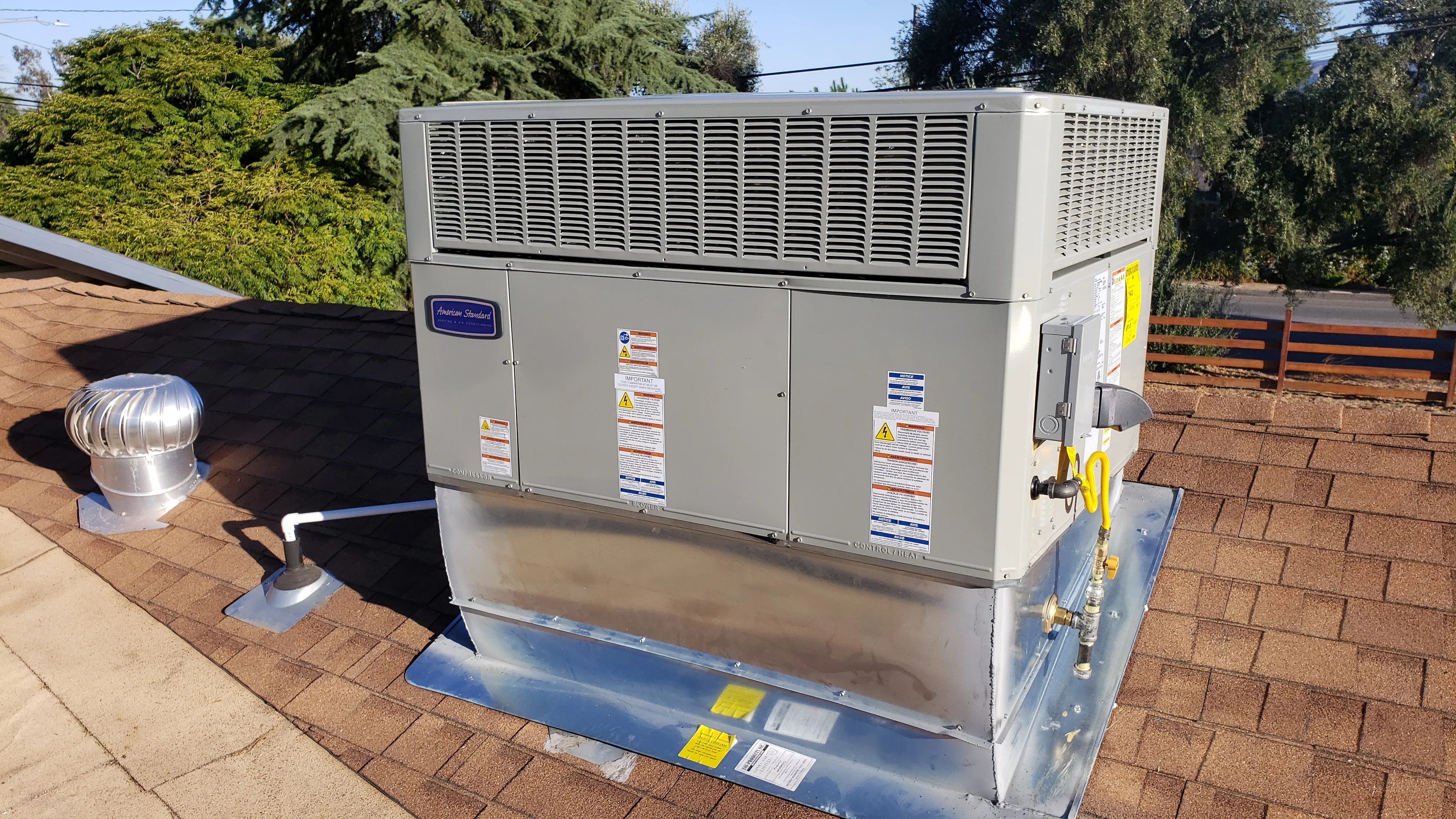 New rooftop HVAC unit installation with condenser and air handler on residential roof